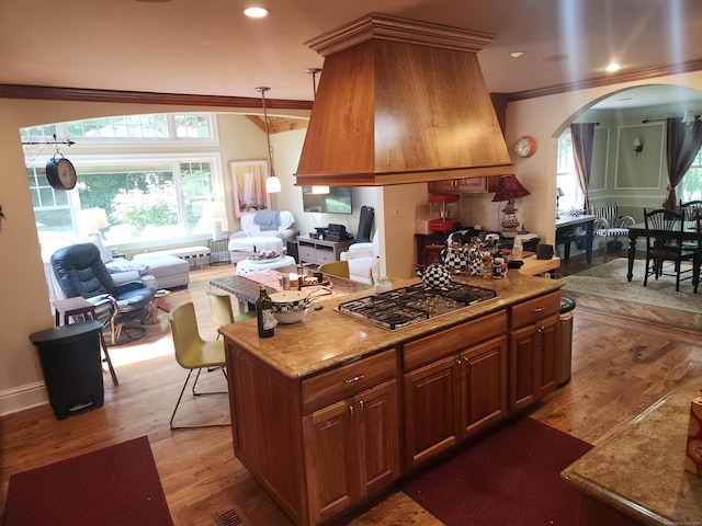 8 Caddy Rd, Norwalk, CT 06851 - kitchen featuring arched walkways, ornamental molding, stainless steel gas stovetop, light wood-style flooring, and open floor plan