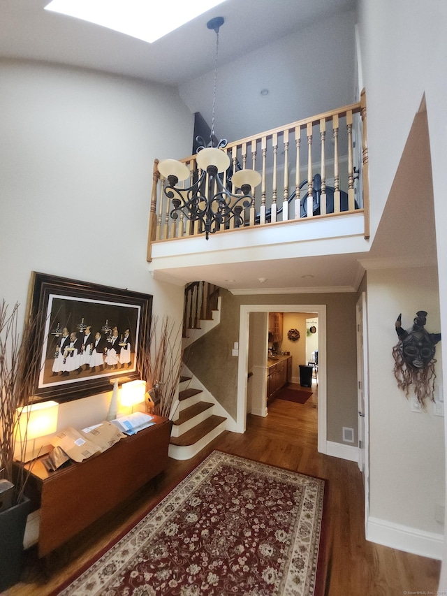 8 Caddy Rd, Norwalk, CT 06851 - stairway featuring a chandelier, a towering ceiling, wood finished floors, ornamental molding, and a skylight