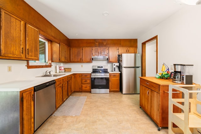 15 Revere Rd, Washington, CT 06793 - kitchen with appliances with stainless steel finishes, under cabinet range hood, light countertops, light flooring, and brown cabinets