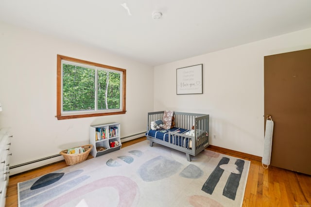 15 Revere Rd, Washington, CT 06793 - bedroom featuring a baseboard heating unit, wood finished floors, and a crib