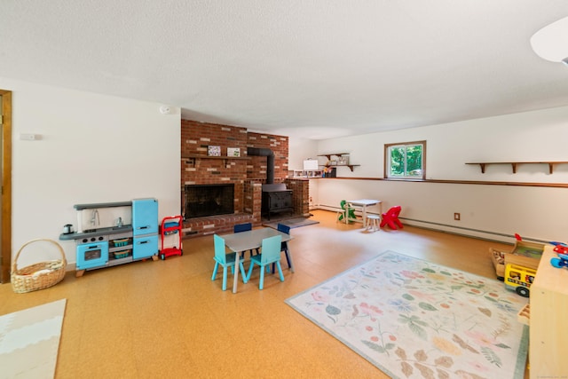 15 Revere Rd, Washington, CT 06793 - playroom with a wood stove, a baseboard radiator, a baseboard heating unit, and a textured ceiling