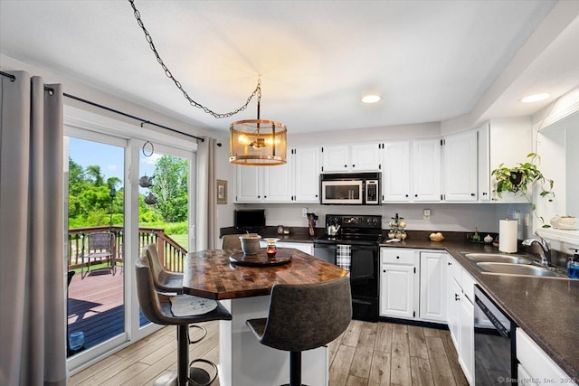 367 Pine Hill Rd, Sterling, CT 06377 - kitchen featuring black appliances, light wood-style floors, recessed lighting, white cabinets, and a kitchen bar