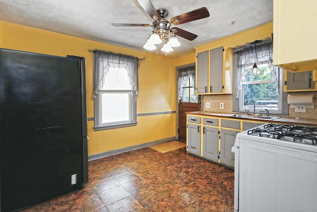 205 Lee St, West Haven, CT 06516 - kitchen with freestanding refrigerator, white gas range, healthy amount of natural light, and backsplash
