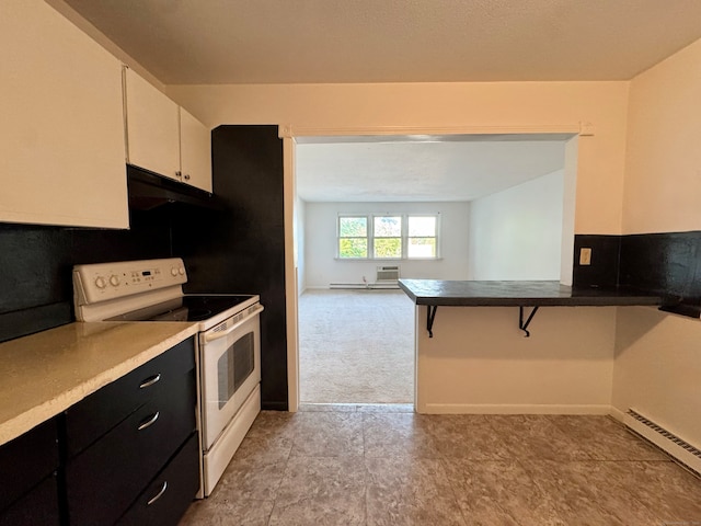 1730 State St Apt 306, Hamden, CT 06517 - kitchen with white range with electric stovetop, a baseboard radiator, dark cabinets, a breakfast bar, and white cabinets