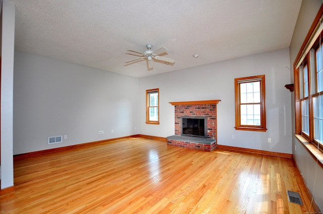 146 Pheasant Way S, Windsor, CT 06074 - unfurnished living room featuring light wood-type flooring, ceiling fan, a fireplace, and a textured ceiling