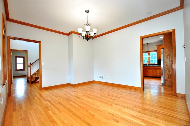 146 Pheasant Way S, Windsor, CT 06074 - empty room with healthy amount of natural light, a chandelier, light wood-style floors, ornamental molding, and stairway