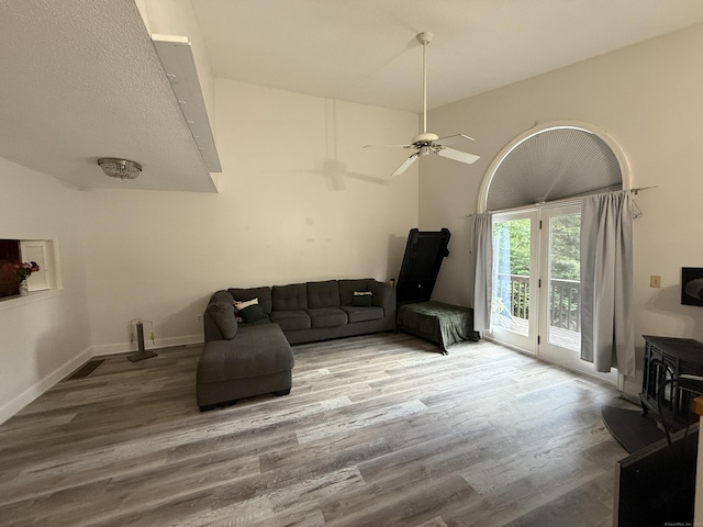 401 Essex Ct Unit 401, Torrington, CT 06790 - living area with wood finished floors, vaulted ceiling, a ceiling fan, and a wood stove
