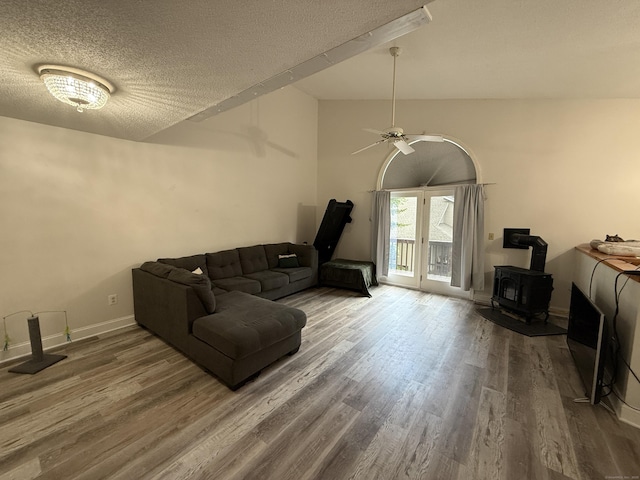 401 Essex Ct Unit 401, Torrington, CT 06790 - living area with a wood stove, wood finished floors, a textured ceiling, a ceiling fan, and lofted ceiling