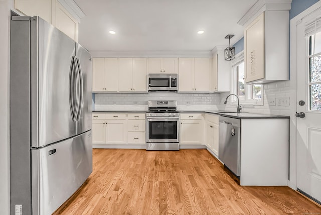 85 Floral Way, Stratford, CT 06615 - kitchen featuring appliances with stainless steel finishes, tasteful backsplash, light wood-style flooring, white cabinets, and recessed lighting