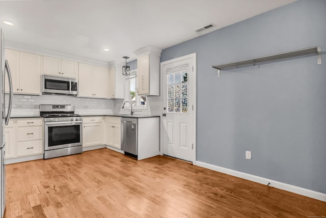 85 Floral Way, Stratford, CT 06615 - kitchen featuring stainless steel appliances, backsplash, light wood finished floors, white cabinetry, and recessed lighting