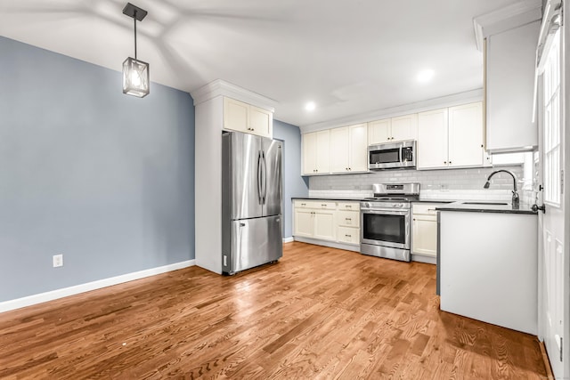 85 Floral Way, Stratford, CT 06615 - kitchen featuring stainless steel appliances, dark countertops, tasteful backsplash, light wood-style flooring, and white cabinets
