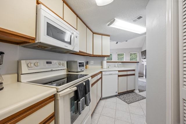 289 Carriage Crossing Ln Unit 289, Middletown, CT 06457 - kitchen featuring white appliances, light countertops, light tile patterned flooring, a textured ceiling, and a peninsula