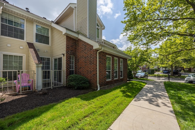 289 Carriage Crossing Ln Unit 289, Middletown, CT 06457 - view of side of property with brick siding, a chimney, and a yard
