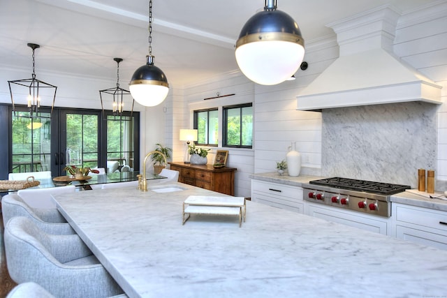 229 Good Hill Rd, Weston, CT 06883 - kitchen with stainless steel gas stovetop, premium range hood, white cabinets, light stone counters, and decorative backsplash