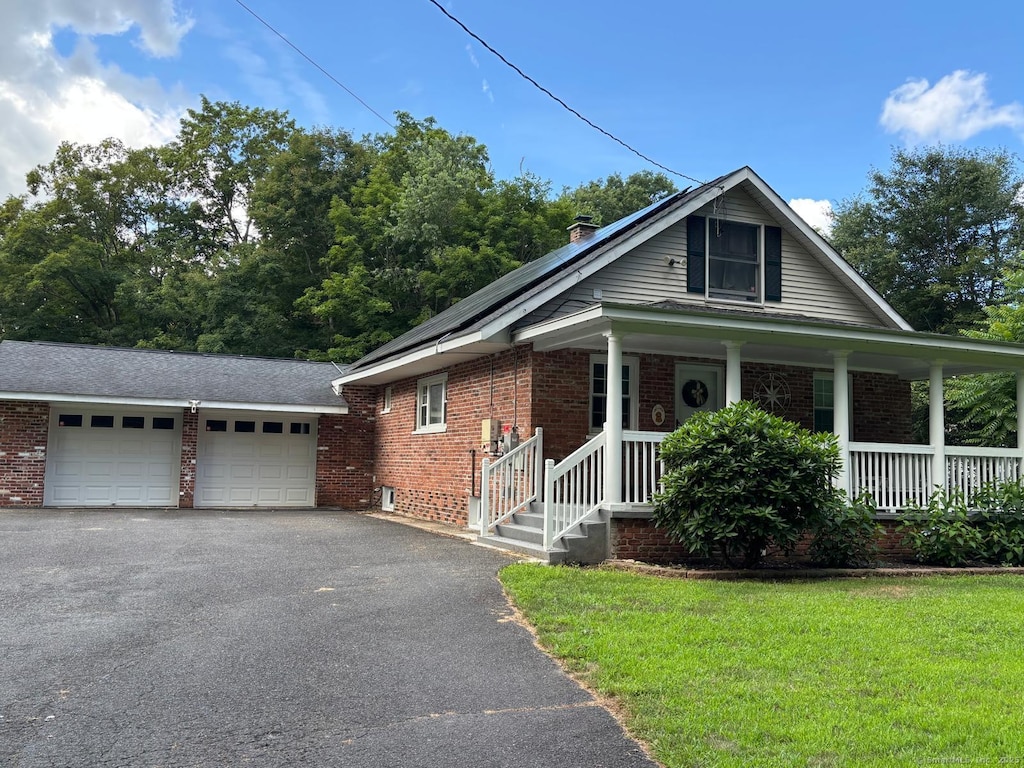 225 Whittemore Rd, Middlebury, CT 06762 - view of front facade with brick siding, asphalt driveway, a front lawn, and covered porch