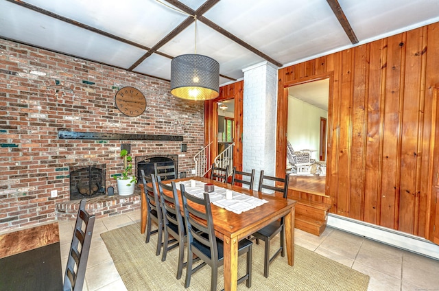 93 Glenrock Rd, Waterbury, CT 06706 - tiled dining space with a baseboard heating unit, a brick fireplace, brick wall, wood walls, and stairs