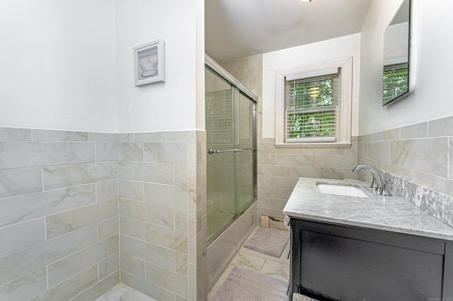 93 Glenrock Rd, Waterbury, CT 06706 - full bathroom with tile walls, vanity, marble look tiles, combined bath / shower with glass door, and a wainscoted wall