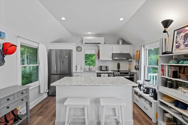 20 Meadow Woods Rd, Essex, CT 06426 - kitchen with stainless steel appliances, under cabinet range hood, vaulted ceiling, a wall unit AC, and white cabinets