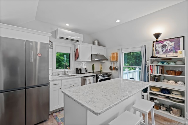 20 Meadow Woods Rd, Essex, CT 06426 - kitchen with appliances with stainless steel finishes, under cabinet range hood, a wall unit AC, lofted ceiling, and a kitchen breakfast bar