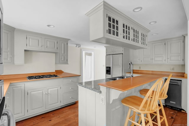 795 Rte 148, Killingworth, CT 06419 - kitchen featuring appliances with stainless steel finishes, wood finished floors, glass insert cabinets, a breakfast bar area, and recessed lighting
