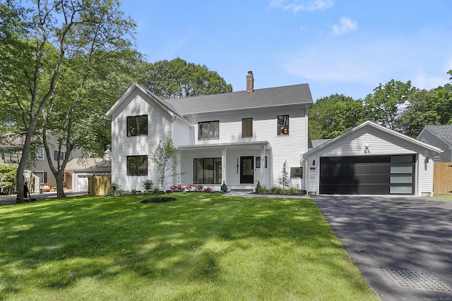 92 Westwood Rd, Fairfield, CT 06825 - view of front of house featuring a chimney, a detached garage, and a front lawn