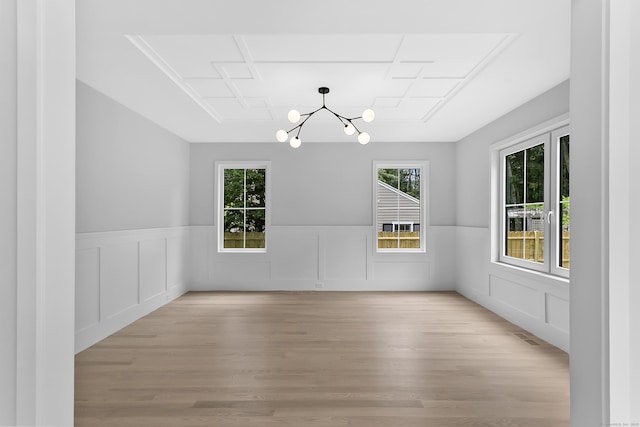 92 Westwood Rd, Fairfield, CT 06825 - unfurnished dining area with a chandelier, plenty of natural light, wainscoting, light wood-style floors, and a decorative wall