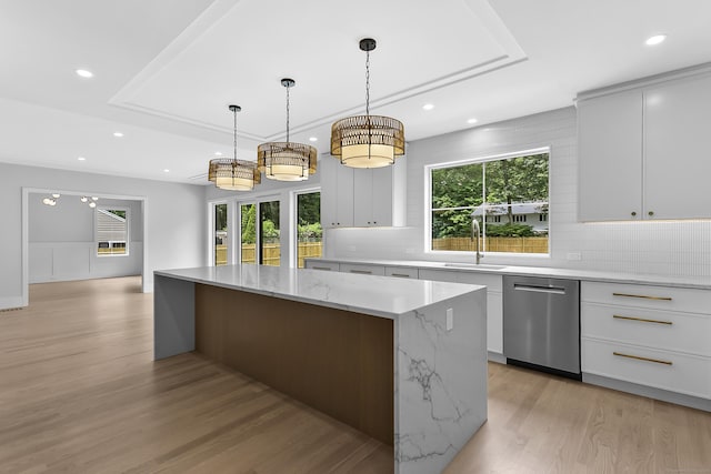 92 Westwood Rd, Fairfield, CT 06825 - kitchen featuring dishwasher, a center island, light wood-style floors, a tray ceiling, and decorative backsplash