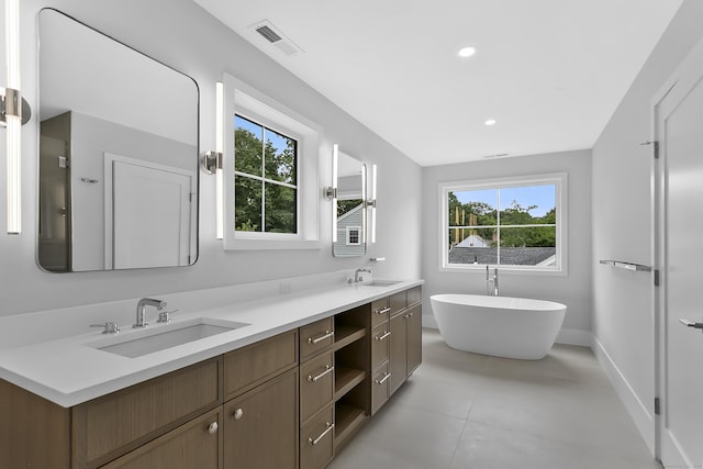 92 Westwood Rd, Fairfield, CT 06825 - full bath with plenty of natural light, double vanity, a freestanding bath, tile patterned flooring, and recessed lighting