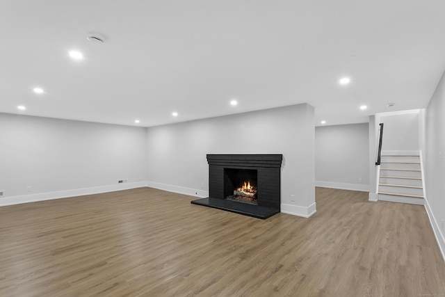 92 Westwood Rd, Fairfield, CT 06825 - unfurnished living room with stairway, recessed lighting, light wood-style flooring, and a brick fireplace