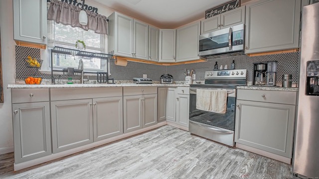 83 View Ter, East Haven, CT 06512 - kitchen featuring stainless steel appliances, tasteful backsplash, light wood-type flooring, and gray cabinets
