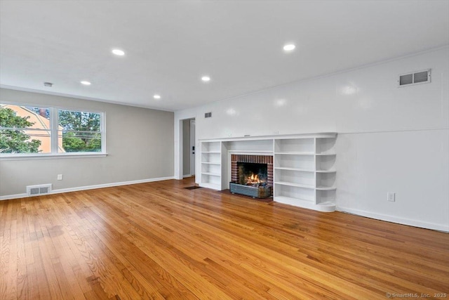 210 Highland Ave, West Haven, CT 06516 - unfurnished living room featuring light wood-style flooring, recessed lighting, and a brick fireplace