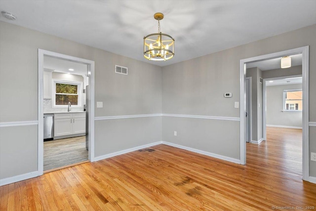 210 Highland Ave, West Haven, CT 06516 - empty room featuring a smoke detector, a chandelier, light wood-type flooring, and plenty of natural light