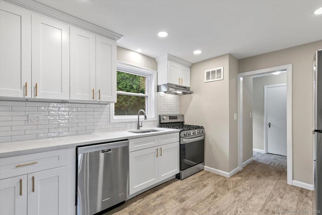 210 Highland Ave, West Haven, CT 06516 - kitchen with stainless steel appliances, under cabinet range hood, light wood-style floors, white cabinets, and backsplash