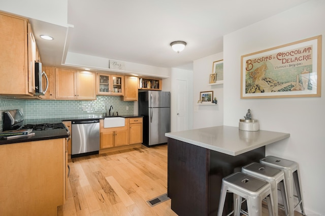 76 Cedarcrest Ct Unit 76, Shelton, CT 06484 - kitchen featuring appliances with stainless steel finishes, a peninsula, a breakfast bar area, open shelves, and decorative backsplash