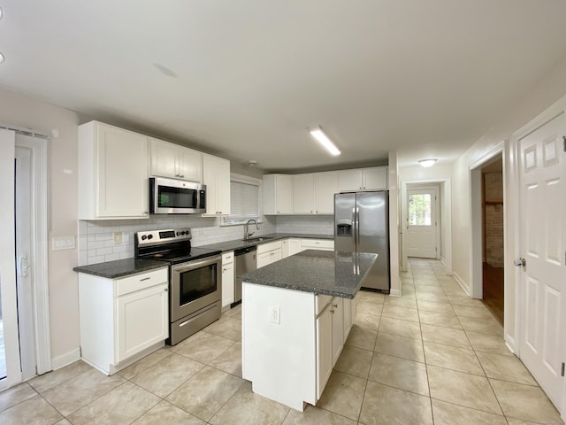 260 Stearns Rd, Mansfield, CT 06268 - kitchen with appliances with stainless steel finishes, decorative backsplash, white cabinets, a center island, and light tile patterned floors