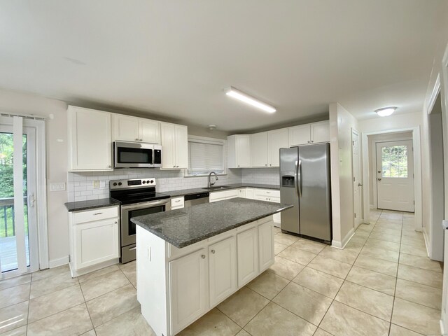 260 Stearns Rd, Mansfield, CT 06268 - kitchen featuring stainless steel appliances, tasteful backsplash, light tile patterned flooring, white cabinetry, and a center island