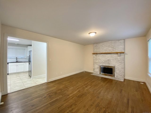 260 Stearns Rd, Mansfield, CT 06268 - unfurnished living room with a brick fireplace and wood finished floors