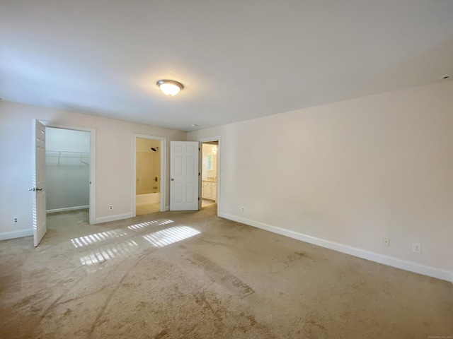 260 Stearns Rd, Mansfield, CT 06268 - unfurnished bedroom with light colored carpet, a walk in closet, and connected bathroom