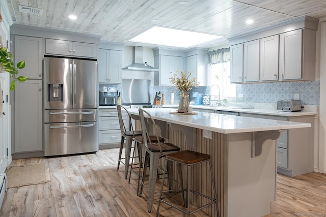 3 Olde Salem Dr, Somers, CT 06071 - kitchen with stainless steel fridge with ice dispenser, wall chimney range hood, light countertops, a breakfast bar area, and recessed lighting