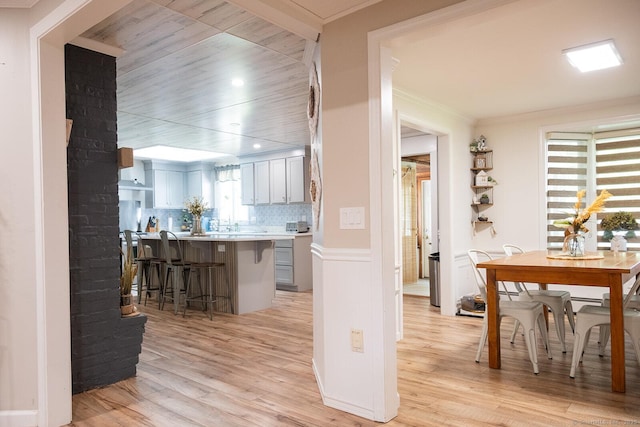 3 Olde Salem Dr, Somers, CT 06071 - kitchen featuring a breakfast bar, light wood-style floors, light countertops, decorative backsplash, and a peninsula