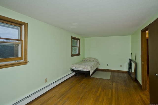 9 Mountain Rd, Granby, CT 06060 - unfurnished bedroom with a baseboard heating unit and dark wood finished floors