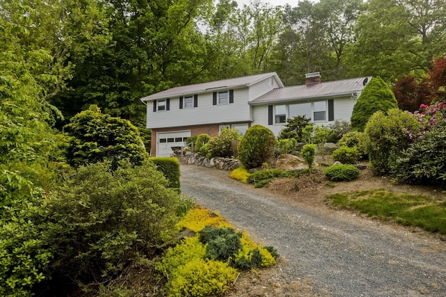 9 Mountain Rd, Granby, CT 06060 - view of front of property featuring asphalt driveway, a garage, a chimney, and a metal roof