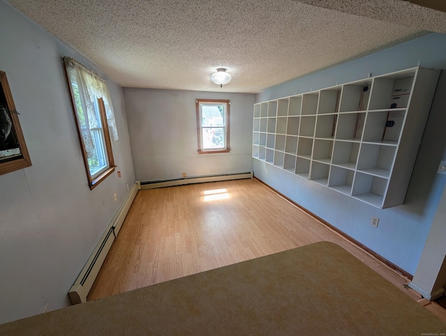 79 Dallas Ave, Plainville, CT 06062 - unfurnished room featuring a baseboard heating unit, wood finished floors, healthy amount of natural light, and a textured ceiling