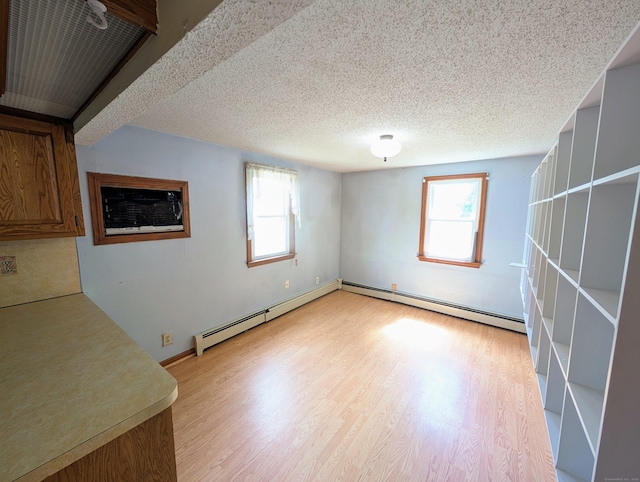 79 Dallas Ave, Plainville, CT 06062 - empty room featuring healthy amount of natural light, light wood-style floors, a baseboard radiator, and a textured ceiling