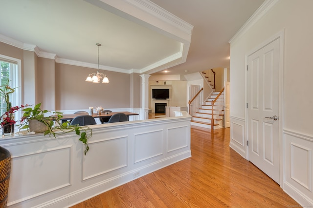 188 Sterling Dr Unit 188, Newington, CT 06111 - kitchen featuring a fireplace, a decorative wall, crown molding, light wood-style flooring, and a chandelier