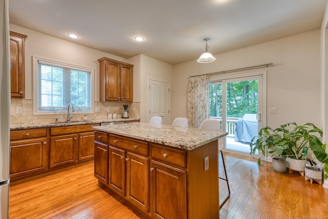 188 Sterling Dr Unit 188, Newington, CT 06111 - kitchen with brown cabinetry, healthy amount of natural light, light wood-style floors, a breakfast bar, and recessed lighting
