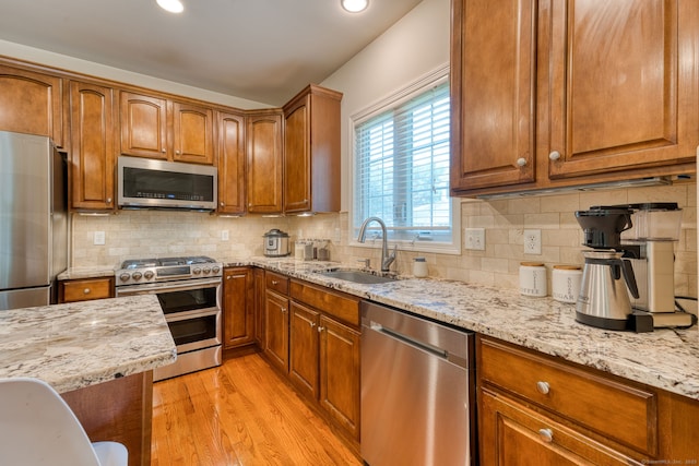 188 Sterling Dr Unit 188, Newington, CT 06111 - kitchen featuring stainless steel appliances, brown cabinetry, light stone countertops, light wood-style flooring, and recessed lighting