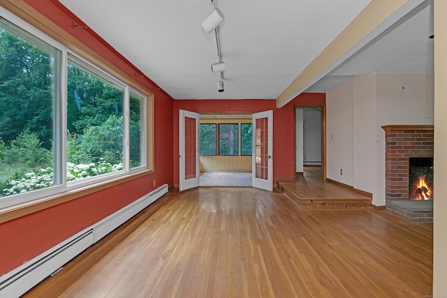 27 Tuttle Ct, Bethany, CT 06524 - unfurnished living room featuring baseboard heating, plenty of natural light, and hardwood / wood-style floors
