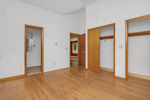 27 Tuttle Ct, Bethany, CT 06524 - unfurnished bedroom with two closets, light wood-type flooring, and a baseboard radiator