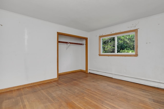 27 Tuttle Ct, Bethany, CT 06524 - unfurnished bedroom with a baseboard heating unit, wood-type flooring, ornamental molding, and a closet